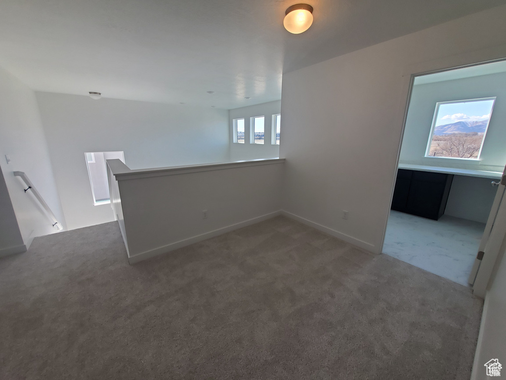 Spare room with baseboards and light colored carpet