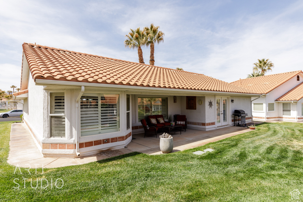 Back of house with a tiled roof, a patio area, and stucco siding