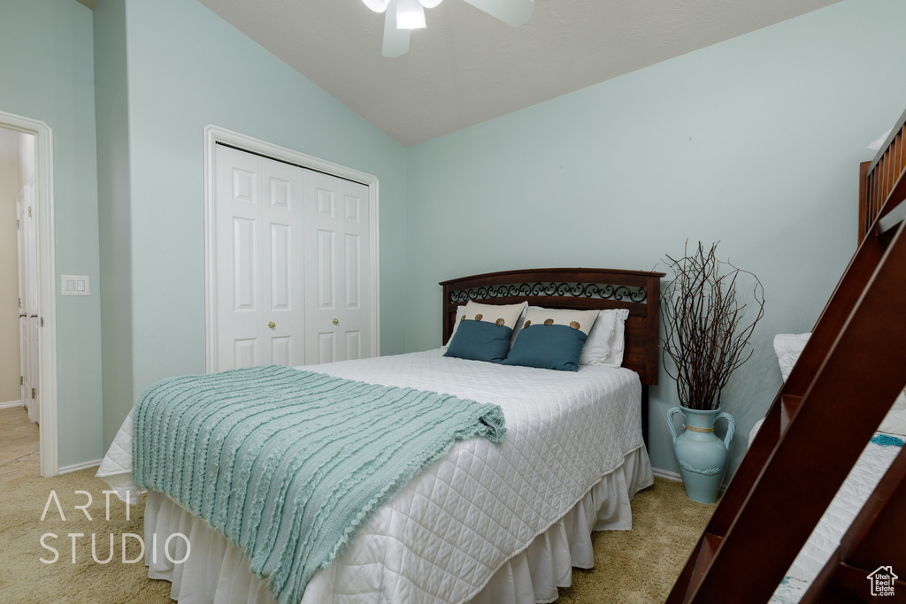 Carpeted bedroom with baseboards, a closet, vaulted ceiling, and a ceiling fan