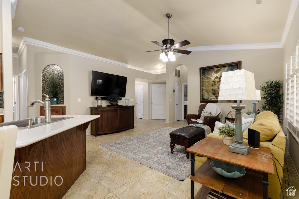 Living area with ceiling fan, crown molding, and lofted ceiling