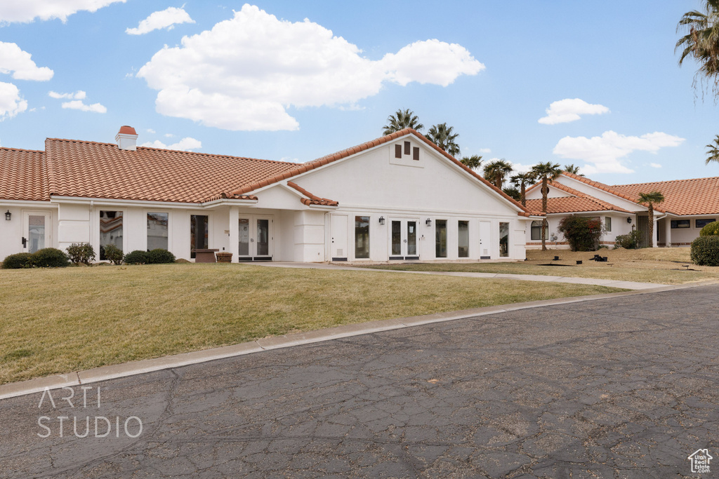 Mediterranean / spanish-style house with a chimney, french doors, stucco siding, and a tiled roof