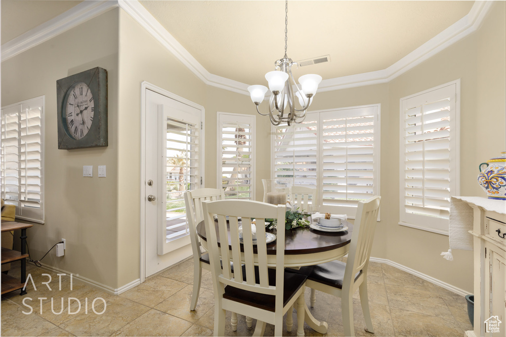 Dining room featuring visible vents, baseboards, an inviting chandelier, and ornamental molding