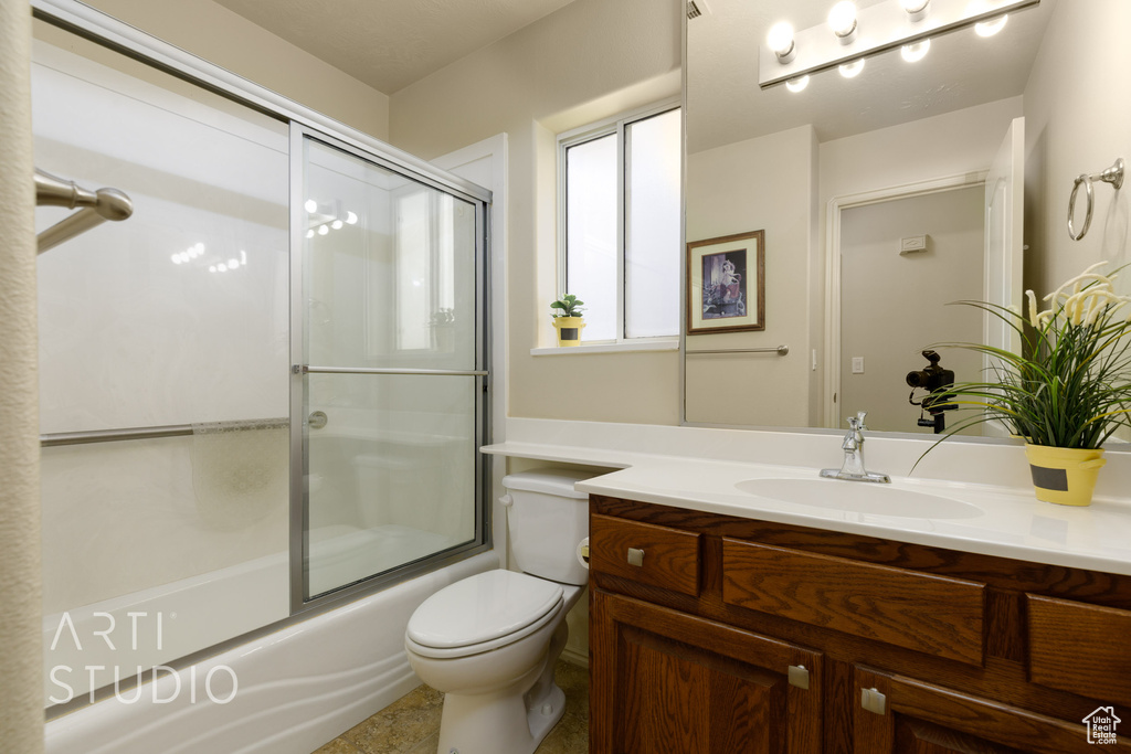 Full bath featuring toilet, vanity, and enclosed tub / shower combo