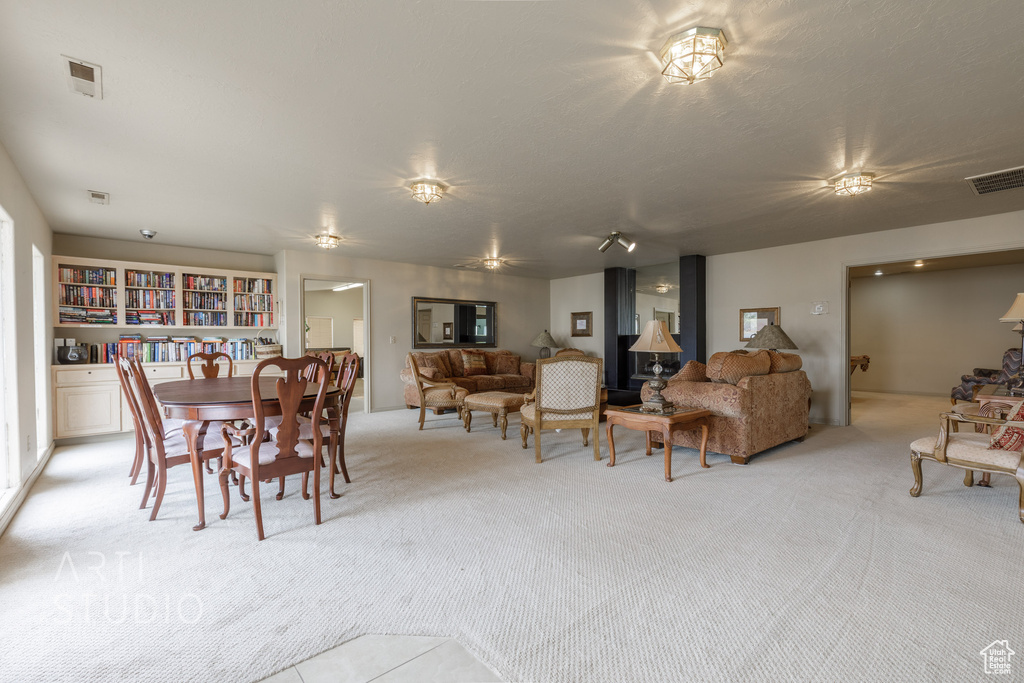 Dining area featuring light carpet and visible vents