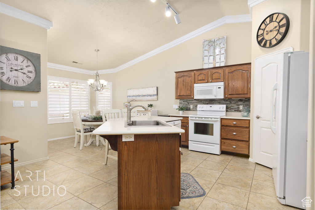 Kitchen with an inviting chandelier, white appliances, ornamental molding, light countertops, and a sink