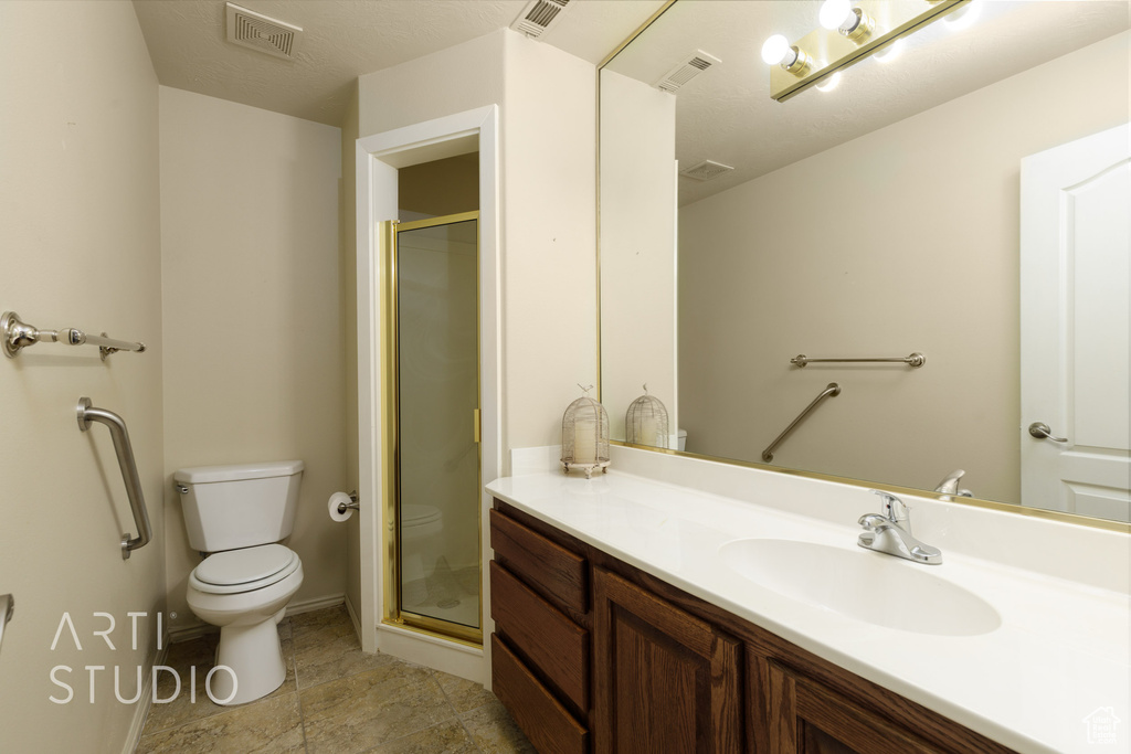 Full bathroom with vanity, visible vents, a stall shower, and toilet