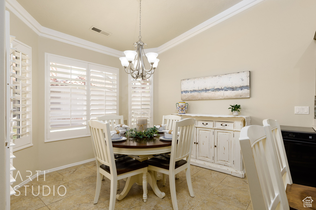 Dining area with crown molding, visible vents, baseboards, and an inviting chandelier