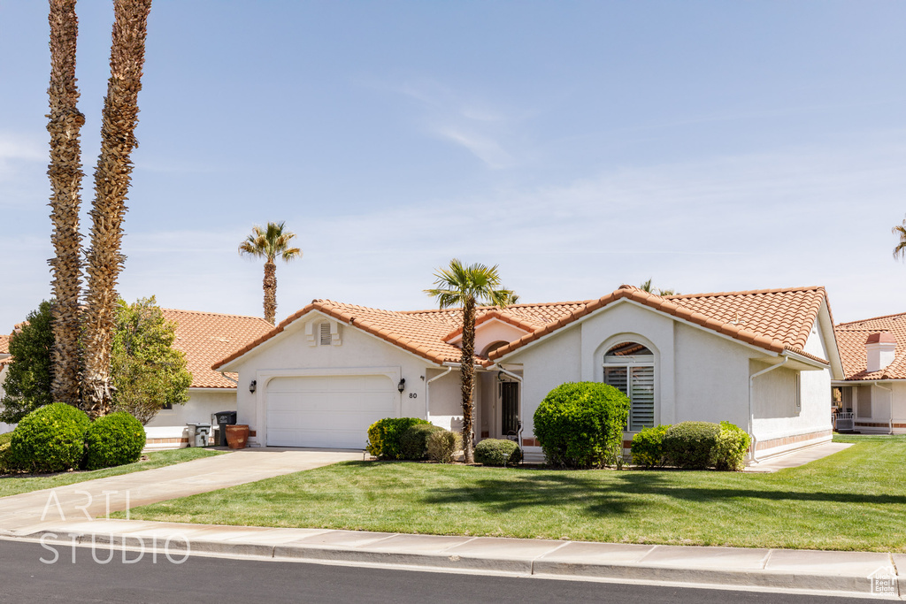 Mediterranean / spanish home featuring a tiled roof, a garage, stucco siding, and concrete driveway