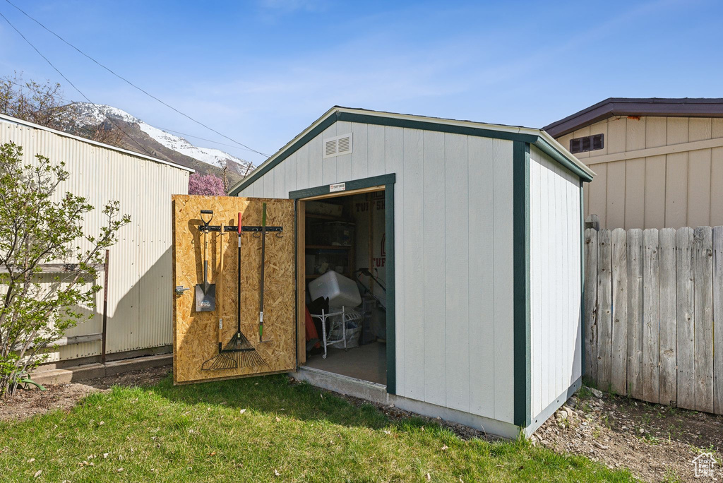 View of shed featuring a mountain view and fence