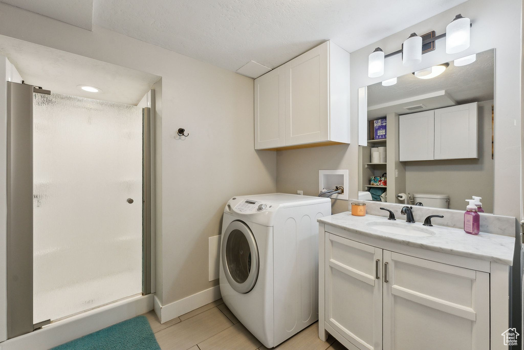 Laundry area featuring baseboards, washer / dryer, laundry area, and a sink