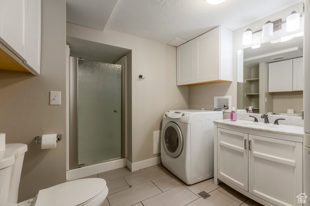 Full bath featuring washer / clothes dryer, toilet, a shower stall, and vanity