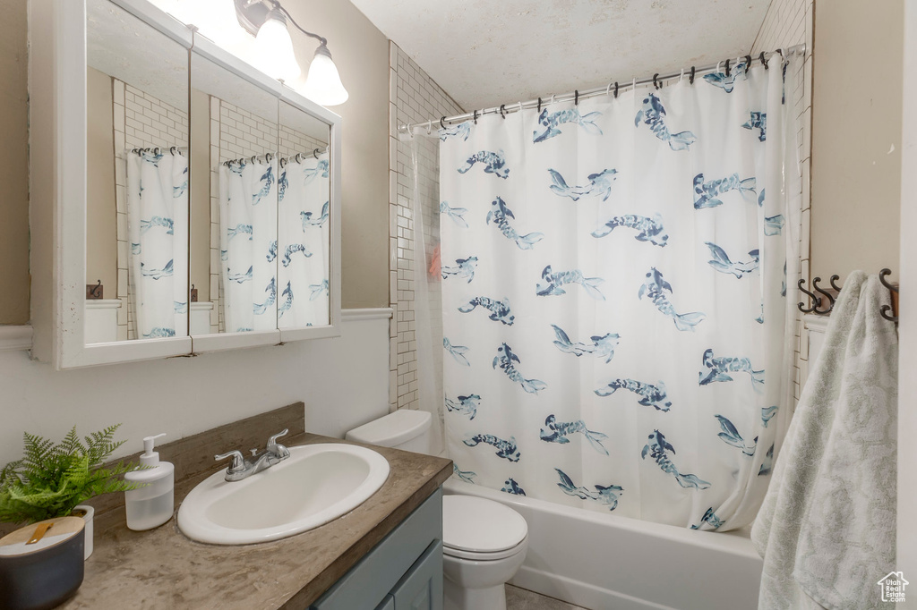 Full bathroom with toilet, vanity, and shower / bathtub combination with curtain