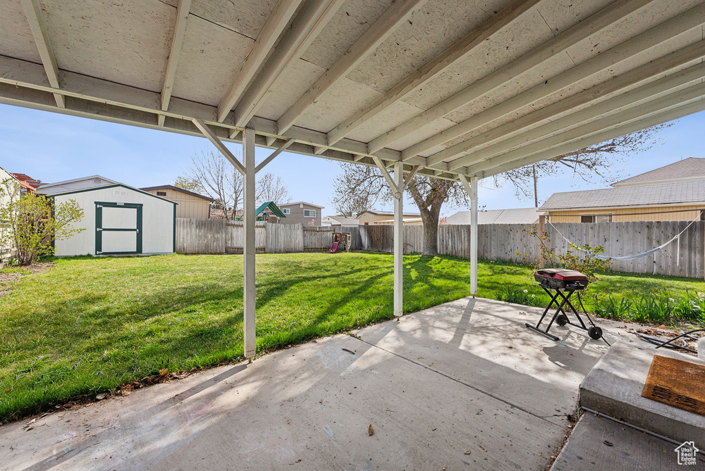 View of patio featuring a fenced backyard, an outdoor structure, and a storage unit