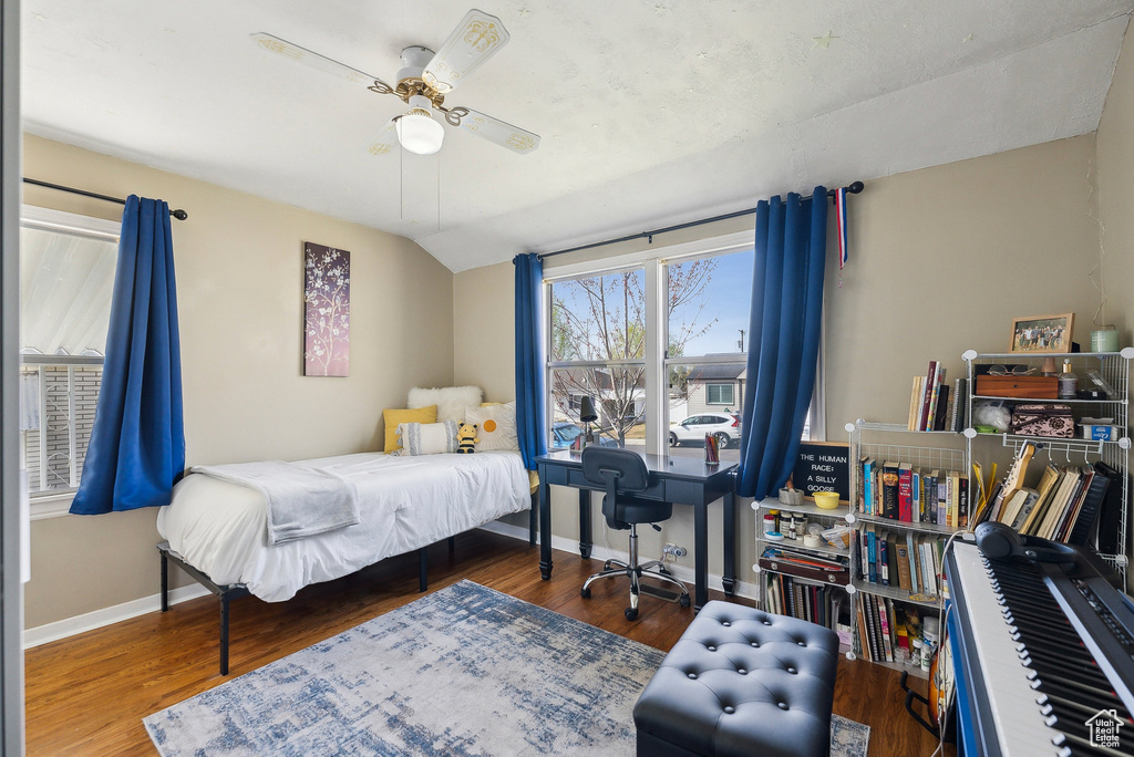 Bedroom featuring wood finished floors, baseboards, a ceiling fan, and vaulted ceiling