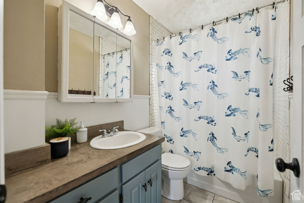Full bath with shower / bath combo, tile patterned flooring, vanity, and toilet