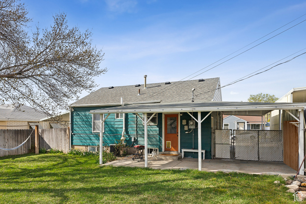 Rear view of house featuring a shingled roof and a patio area
