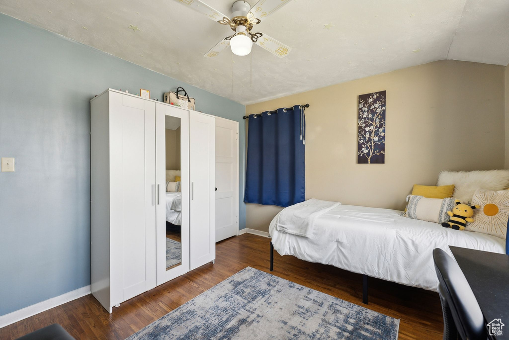 Bedroom with baseboards, a ceiling fan, wood finished floors, and lofted ceiling