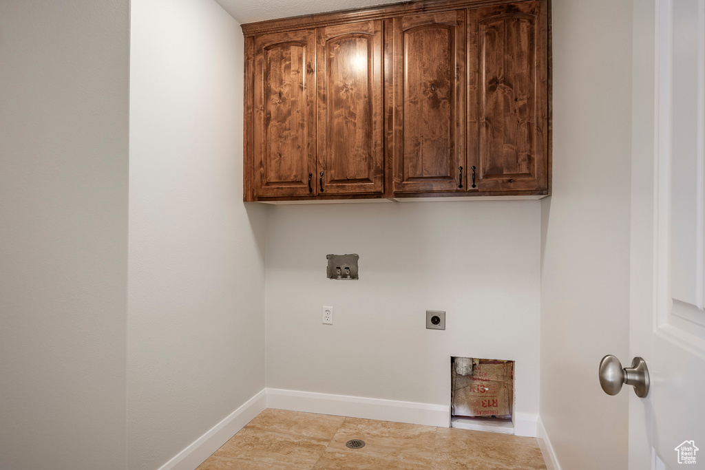 Laundry area with hookup for an electric dryer, baseboards, hookup for a washing machine, and cabinet space