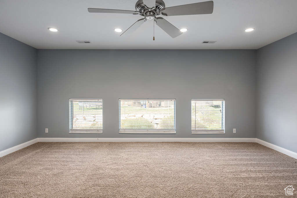 Carpeted spare room featuring recessed lighting, visible vents, baseboards, and ceiling fan