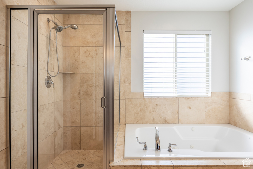 Bathroom featuring a shower stall and a jetted tub