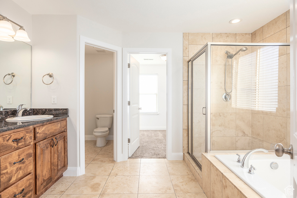 Full bathroom with vanity, a stall shower, tile patterned flooring, toilet, and a bath