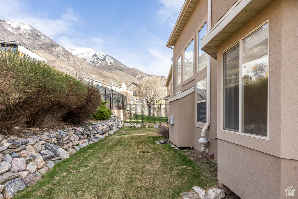 View of yard with a mountain view and fence