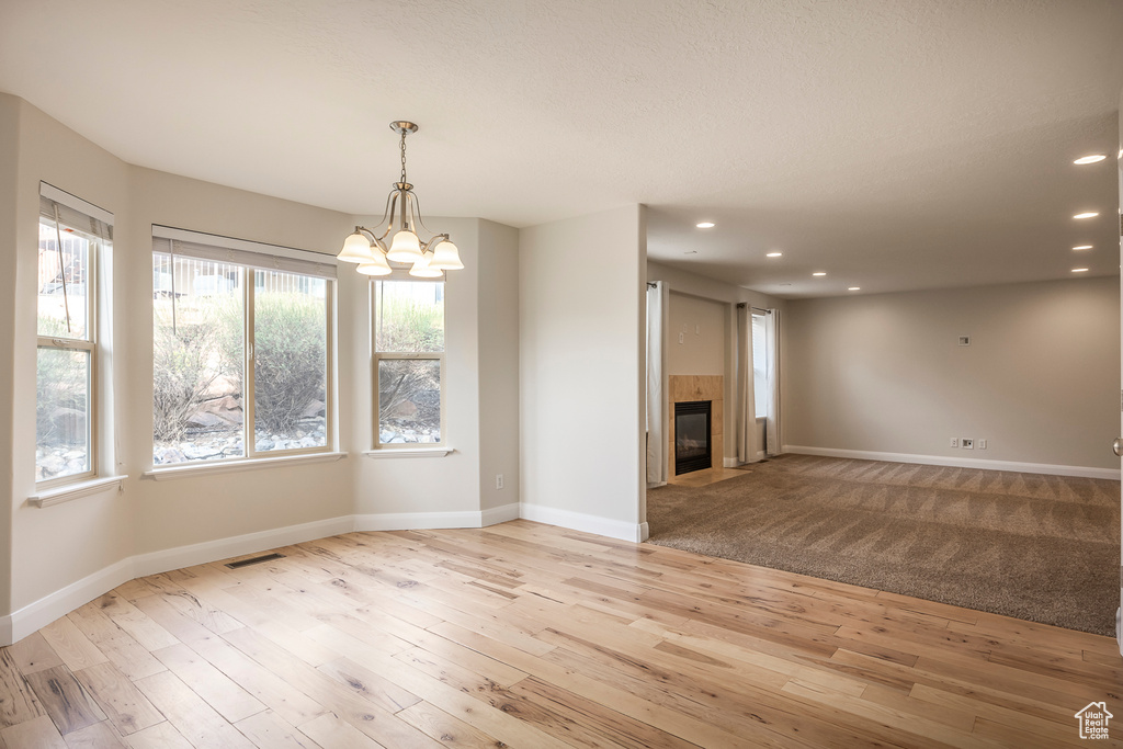 Unfurnished dining area featuring visible vents, light wood finished floors, an inviting chandelier, and recessed lighting