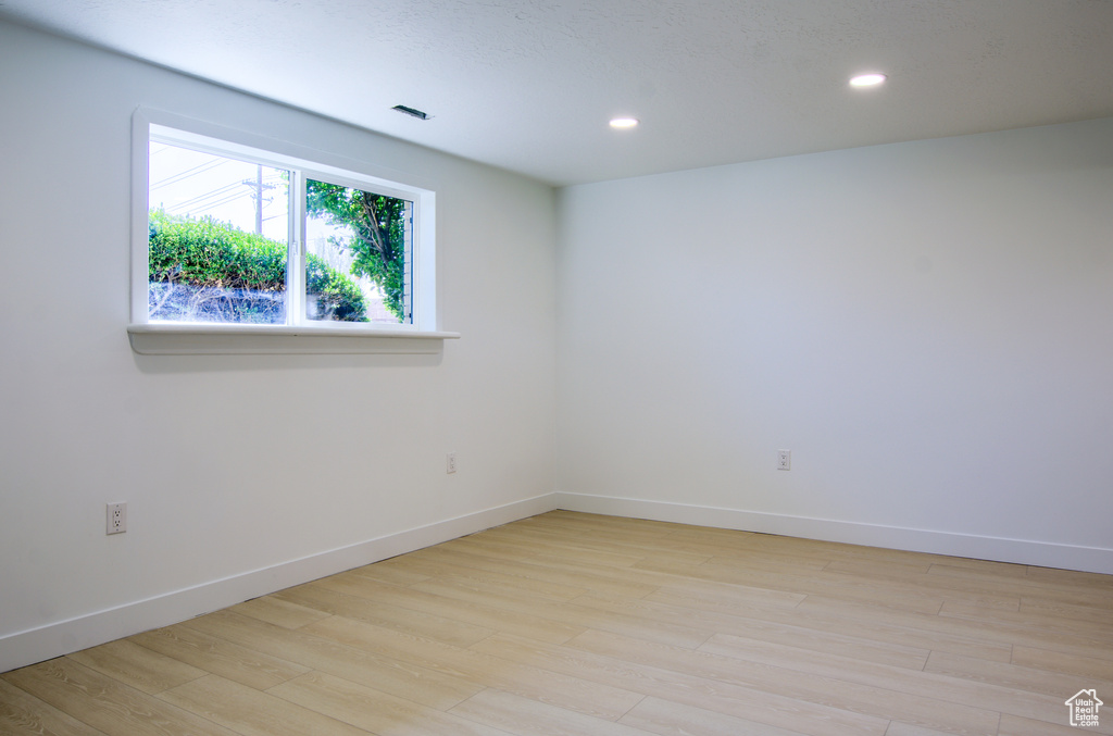 Unfurnished room featuring light wood-type flooring, baseboards, and recessed lighting