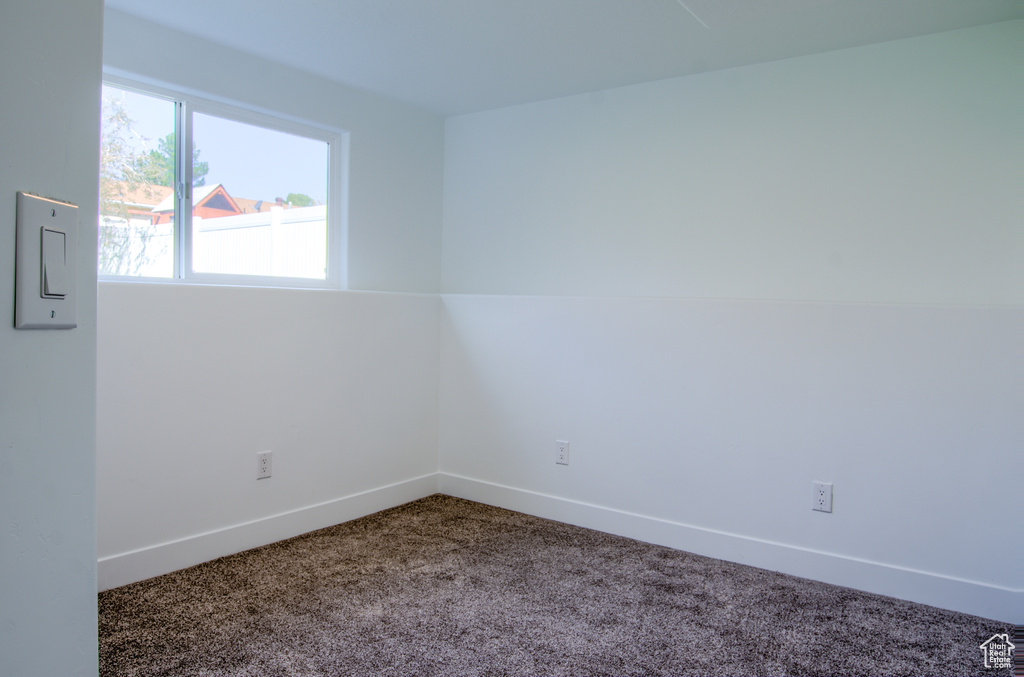 Carpeted spare room with baseboards