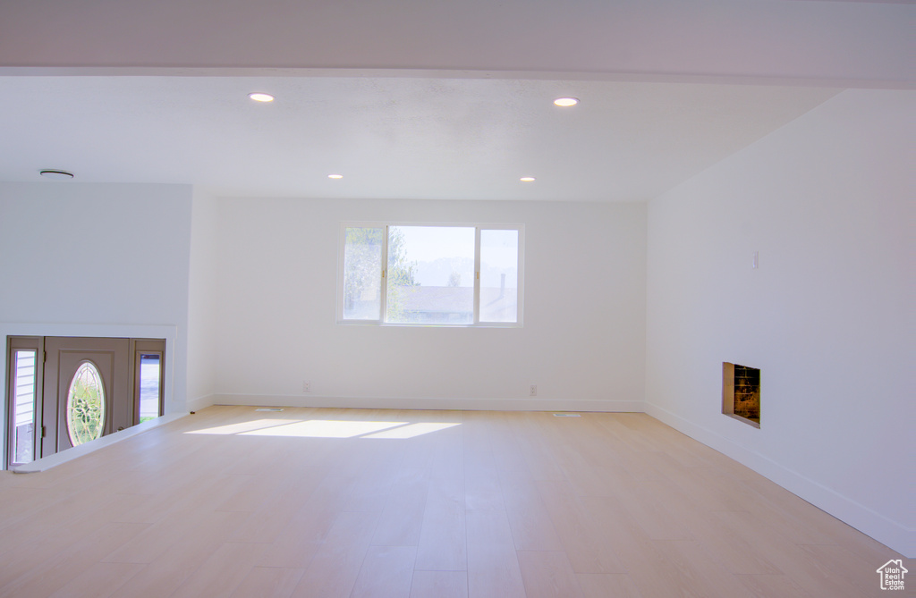Empty room with recessed lighting, a fireplace, light wood-type flooring, and baseboards