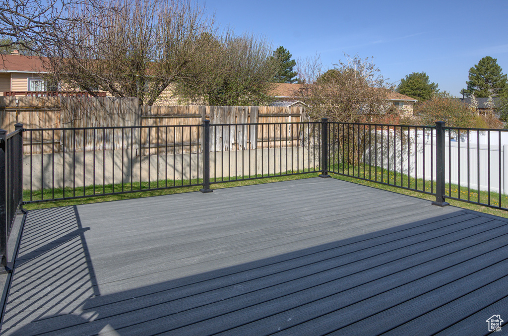 Wooden terrace with a fenced backyard