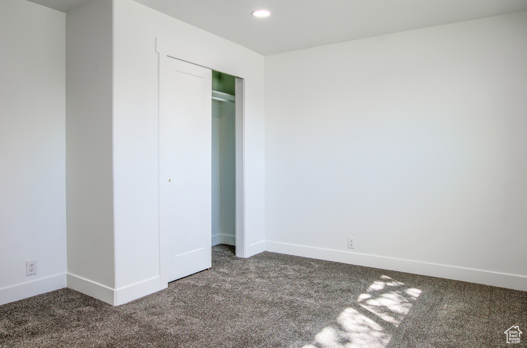 Unfurnished bedroom with a closet, recessed lighting, baseboards, and carpet floors