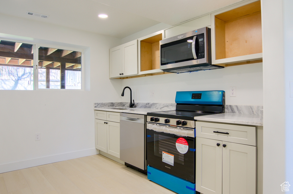 Kitchen with baseboards, light countertops, visible vents, stainless steel appliances, and a sink