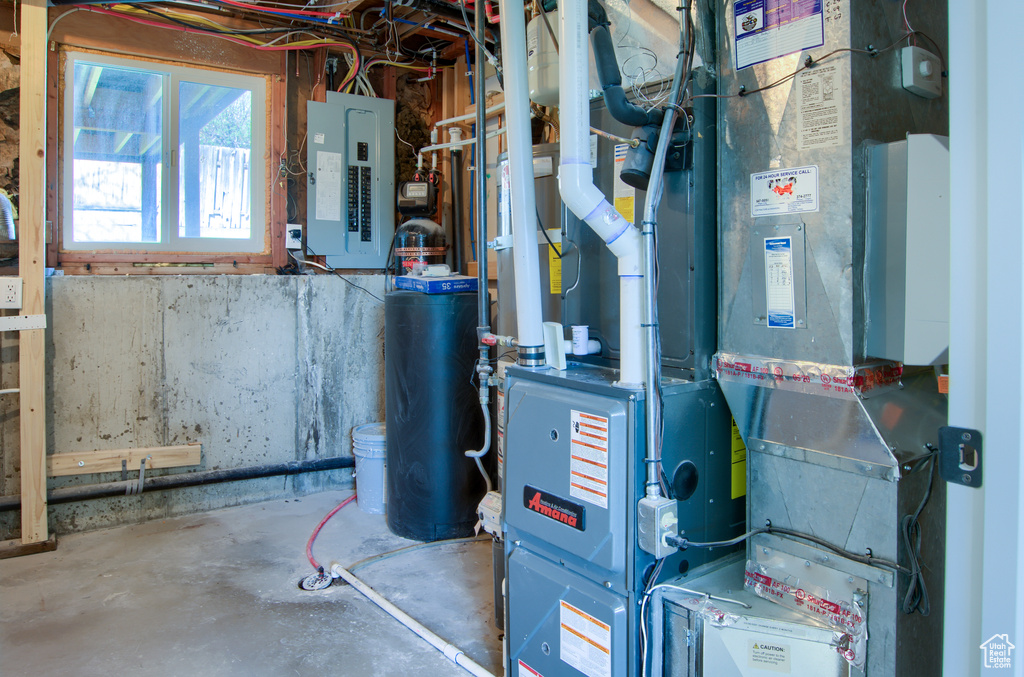 Utility room featuring heating unit and electric panel