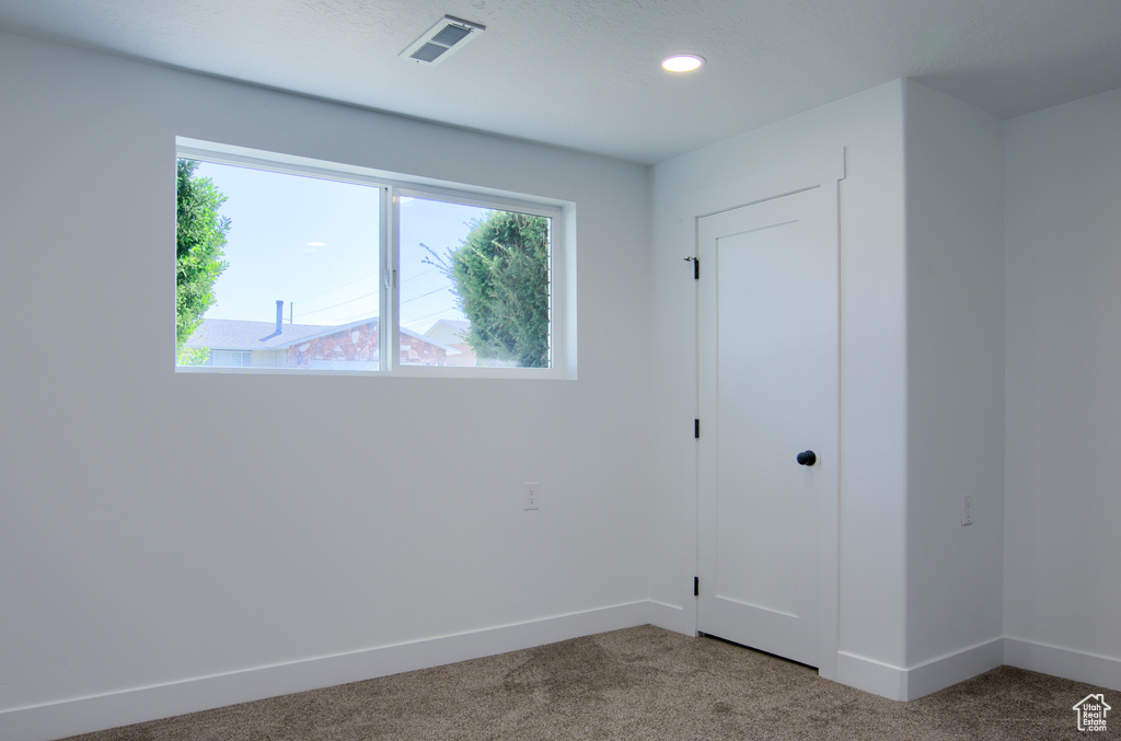 Unfurnished bedroom featuring carpet floors, baseboards, recessed lighting, and visible vents