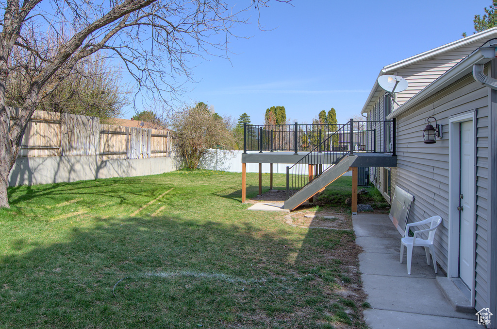 View of yard featuring a fenced backyard, a wooden deck, and stairs
