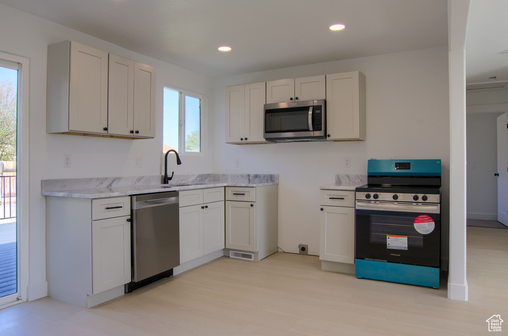 Kitchen with appliances with stainless steel finishes, recessed lighting, a sink, and a wealth of natural light