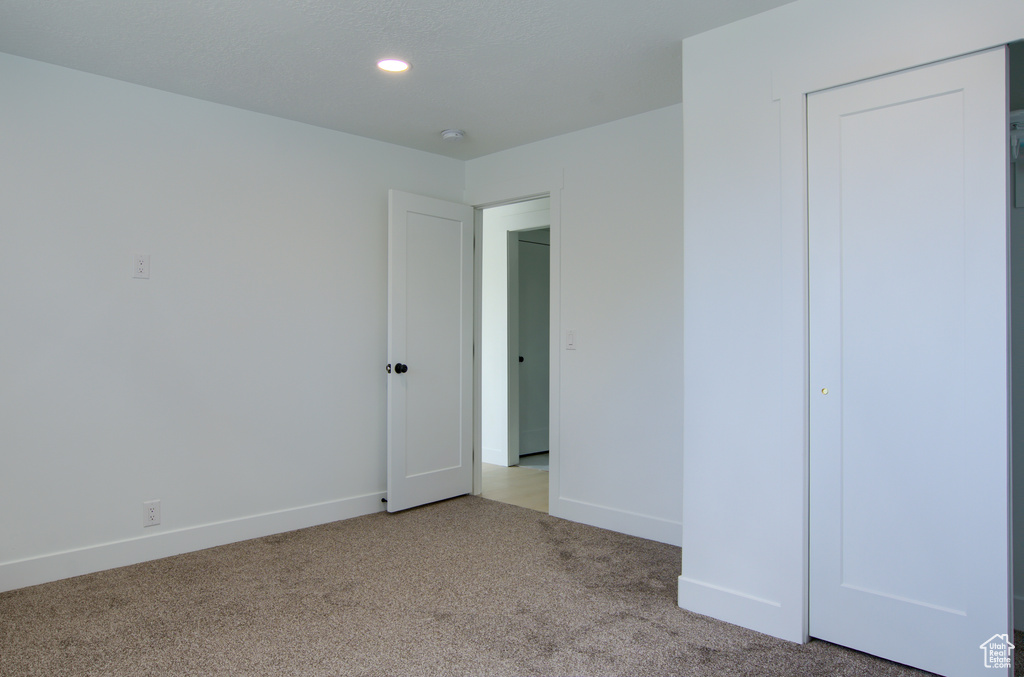 Unfurnished bedroom with carpet flooring, baseboards, and recessed lighting