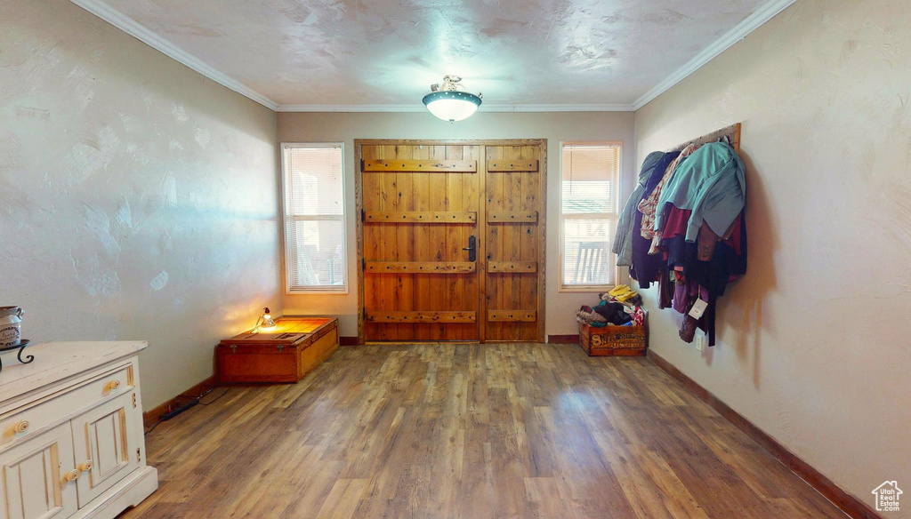 Entryway with wood finished floors and crown molding