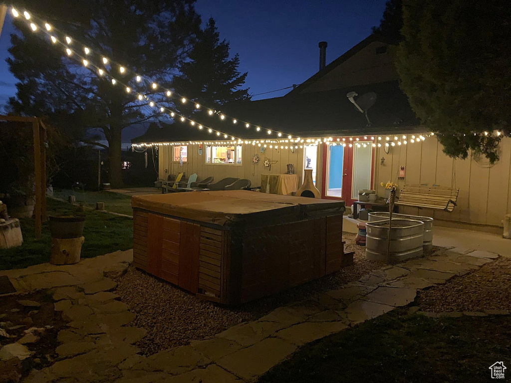 Patio at twilight featuring a hot tub