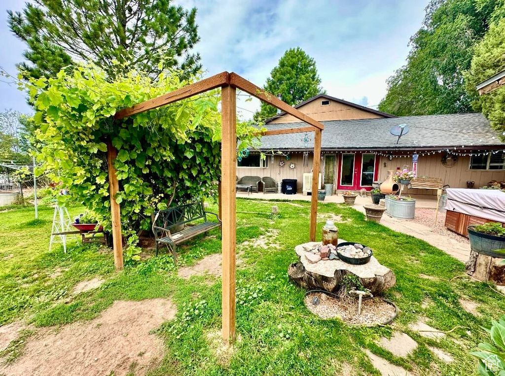 View of yard with a hot tub and a patio area