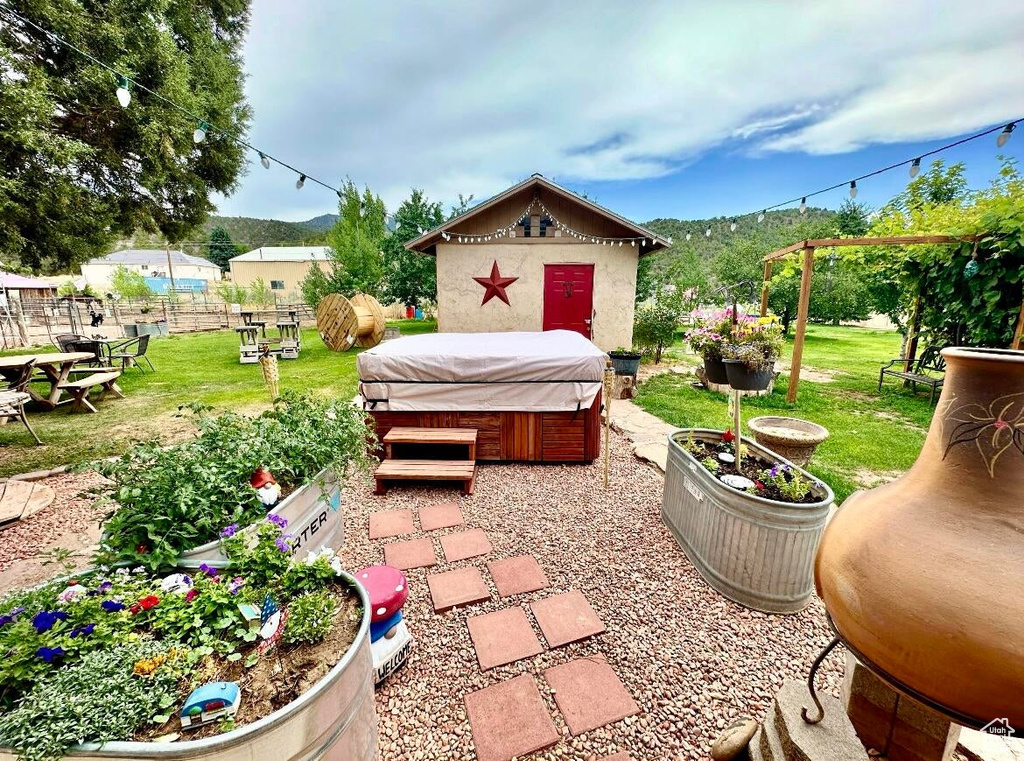 View of patio featuring a hot tub and a mountain view