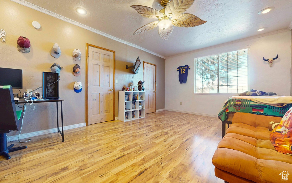 Bedroom with wood finished floors, crown molding, a textured ceiling, recessed lighting, and a desk