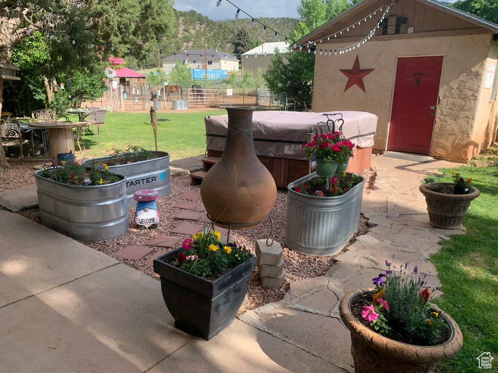 View of patio / terrace featuring a hot tub and an outdoor structure