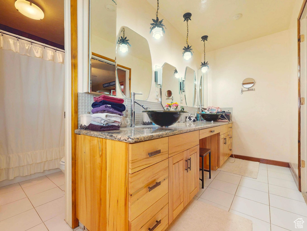 Full bathroom with tile patterned flooring, vanity, and a shower with curtain