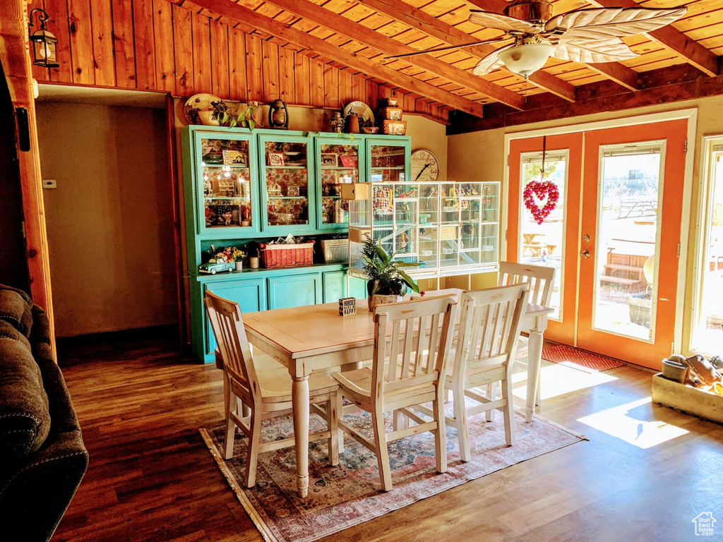 Dining area featuring a ceiling fan, wood finished floors, a wooden ceiling with exposed beams, and french doors