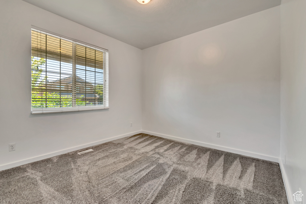 Spare room with carpet and baseboards