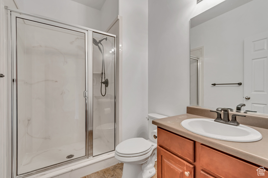Full bathroom featuring vanity, a stall shower, and toilet