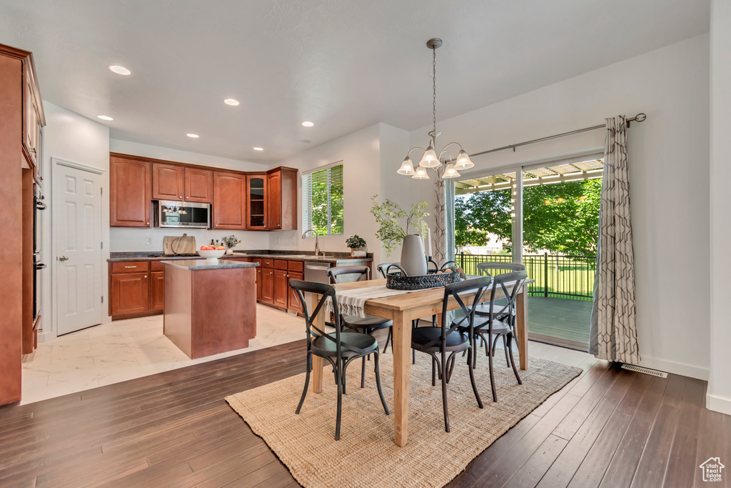 Dining room featuring light wood finished floors, recessed lighting, a chandelier, and baseboards