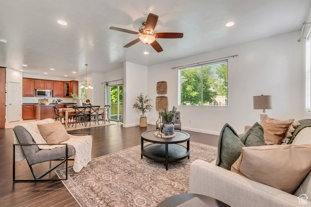 Living area featuring dark wood-style floors, a ceiling fan, recessed lighting, and baseboards